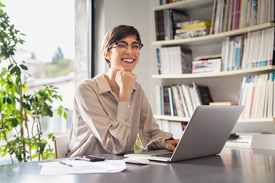 Successful young business woman sitting in creative office and l