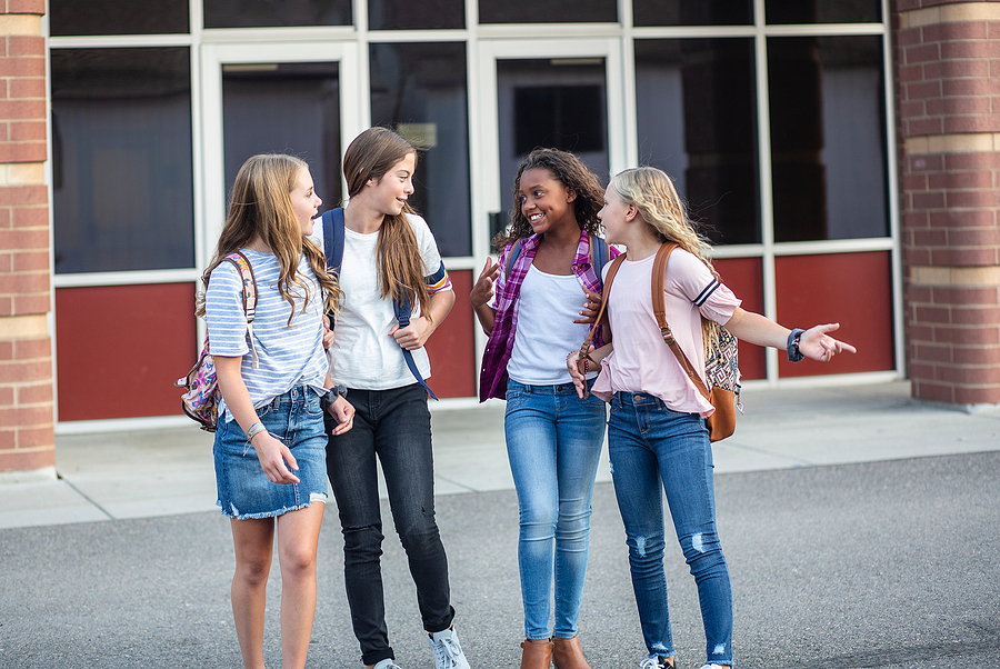 Candid photo of a group of teenage girls socializing, laughing a