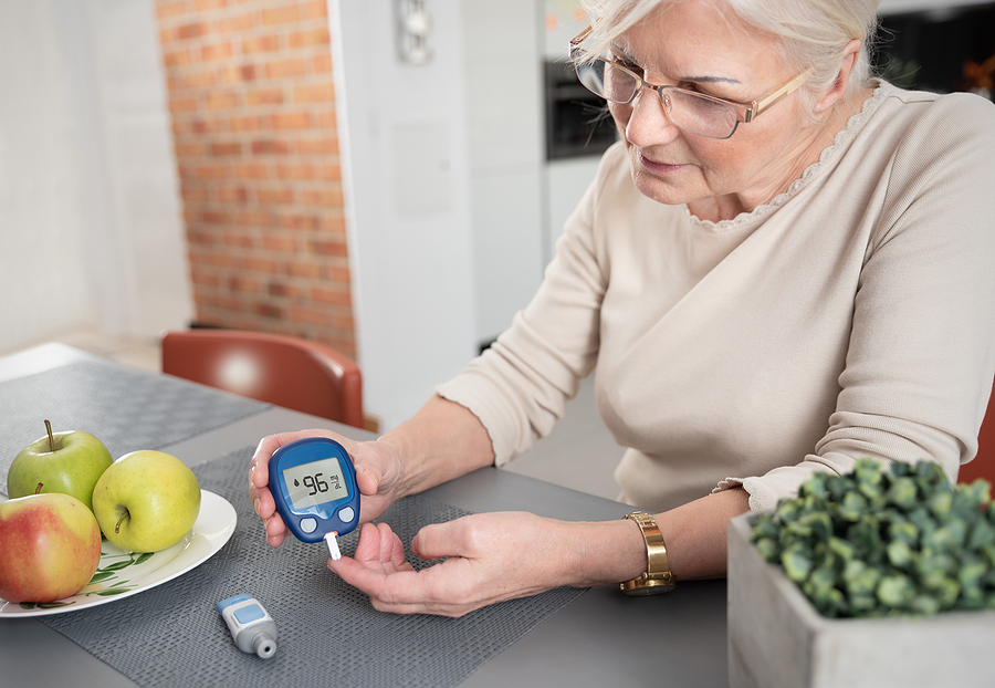 What is type 1 diabetes? Senior woman with glucometer checking blood sugar level at home. Diabetes, health care concept