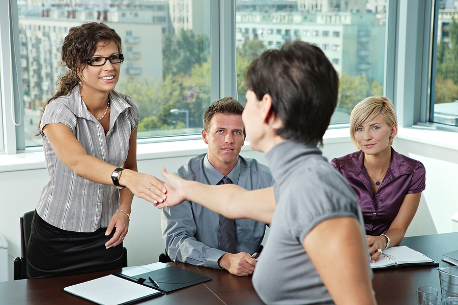 Panel of business people sitting at table in meeting room conduc