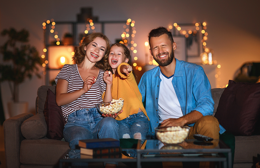 Cable TV vs. Streaming Services: Which One to Choose? family mother father and child daughter watching projector, TV, movies with popcorn in the evening at home