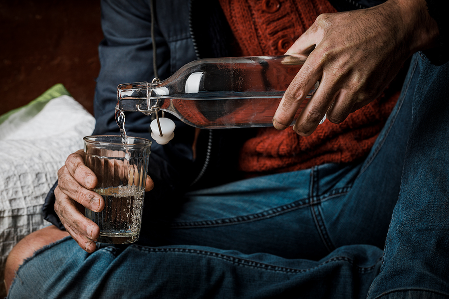 Alcohol problem. A man holds a bottle of alcohol in his hand. Problem with alcohol addiction, alcoholism