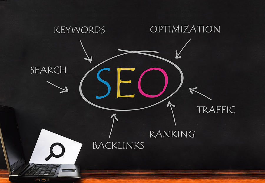 Seo optimization. Laptop on SEO word on dark wall