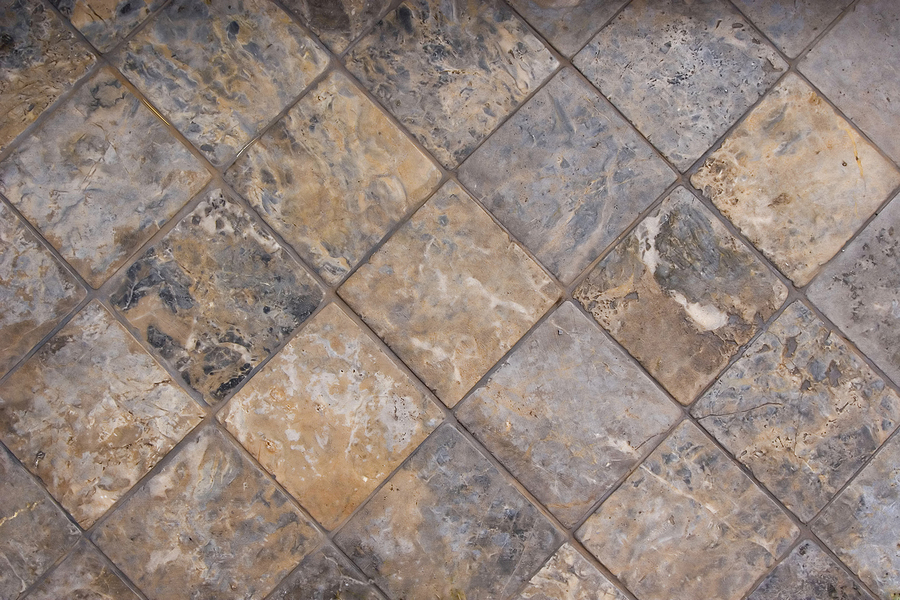 A tile floor made of complimentary earthtone shades of marble.
