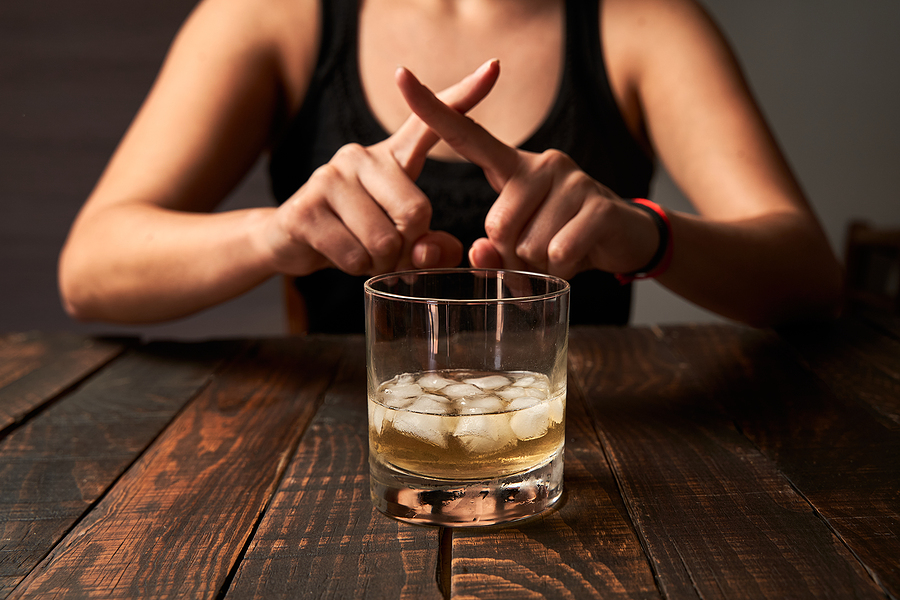 Woman saying no and avoiding drinking alcohol. Concept of alcoholism, addiction and rehabilitation.