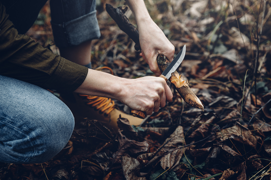 Criteria for choosing your camping knives Woman Traveler Plane Knife With Wooden Stick, Hands Close-up. Bu