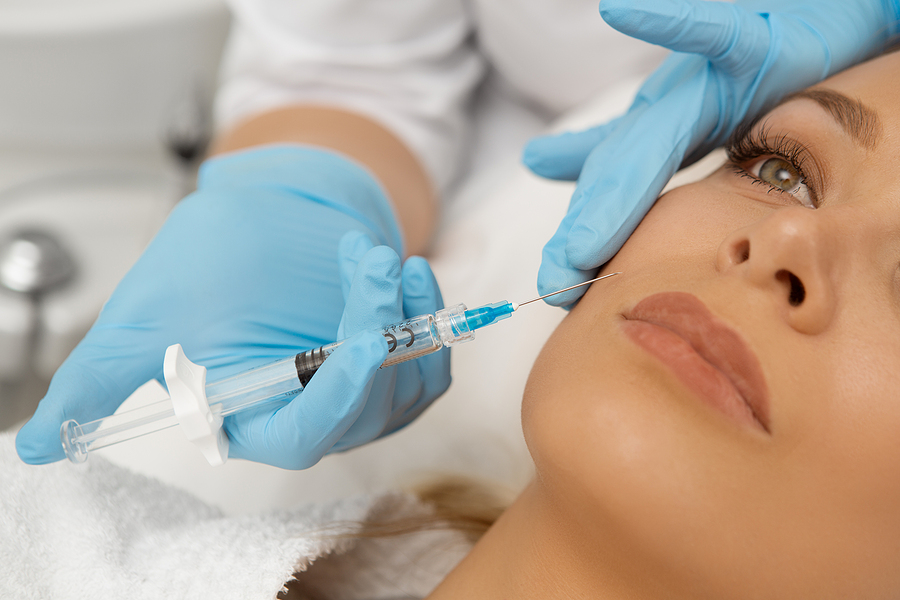 Cropped close up of a young beautiful woman getting fillers injection in her face receiving beauty facial treatment at the clinic plastic surgery botox syringe injector sterile profession procedure