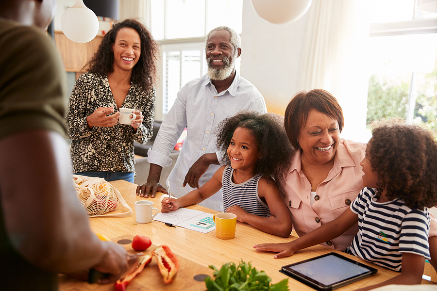 Grandparents Sitting At Table With Grandchildren Playing Games A