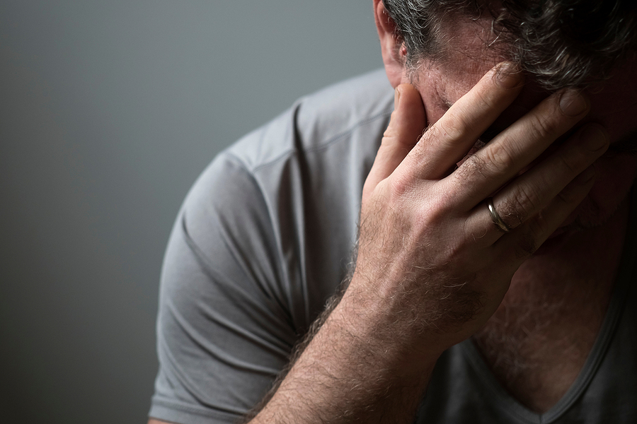 Signs of High-Functioning Depression You Shouldn't Ignore Unhappy sad man in depression covered his face with his hand