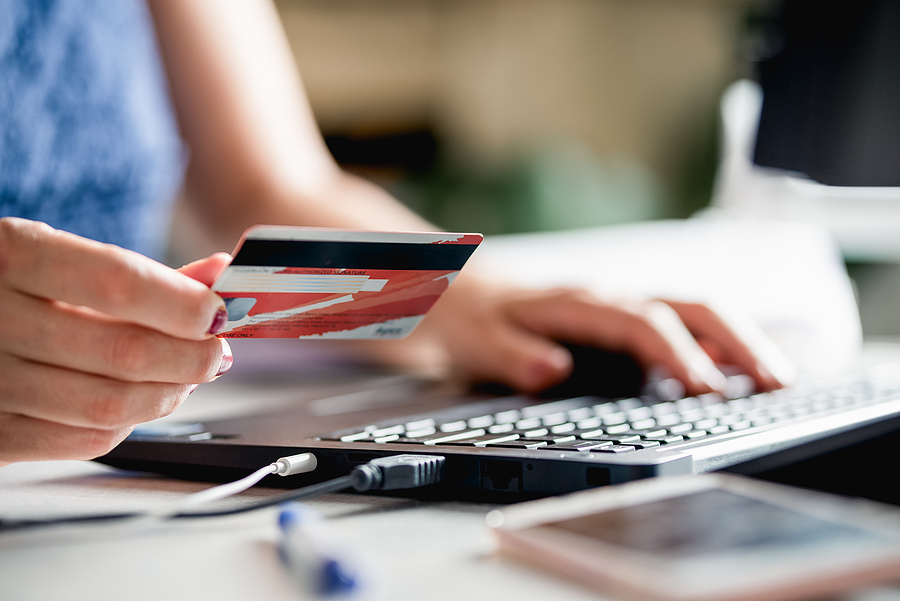 How to increase your credit card limit after opting for a credit card? Woman buying online with credit card. Online shopping. Woman shopping online. Female hands holding credit card using laptop computer to shop online. Online shopping. Paying with credit card online.