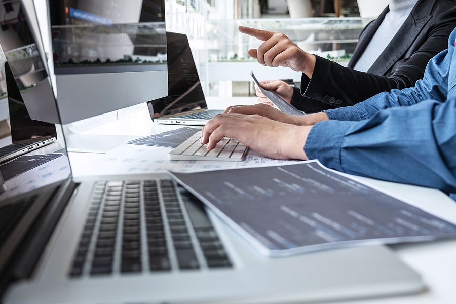 How to Find the Best Software Developers for Your Business Team of developer programmer working on project in software development computer in IT company office, Writing codes and data code website and coding database technologies to find problem solution.