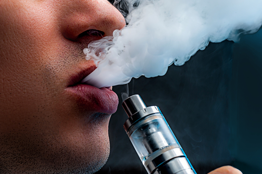 Vape Juices: What You Need To Know Close-up – Young Man Vaping E-cigarette. New Popular Vaping Devi