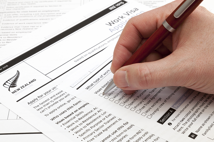 A Man Holding A Ballpoint Pen To Fill A Work Visa Application Fo