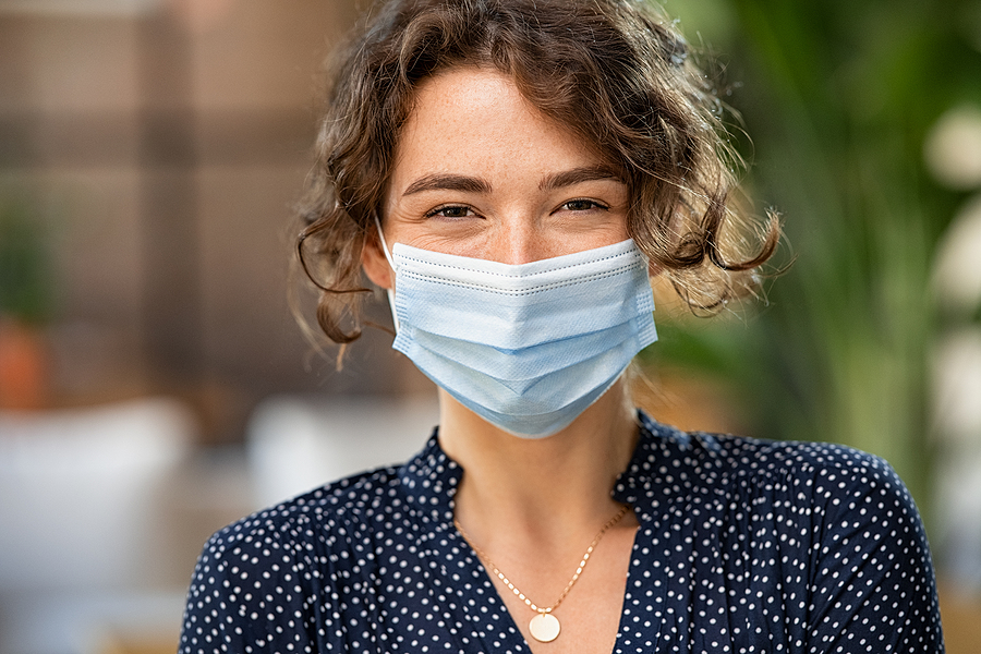 Most Common Symptoms of the Coronavirus Disease and Prevention Portrait of happy young woman wearing face medical mask. Hopeful