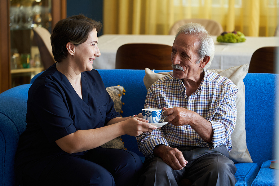Professional Helpful Caregiver And A Senior Man During Home Visi