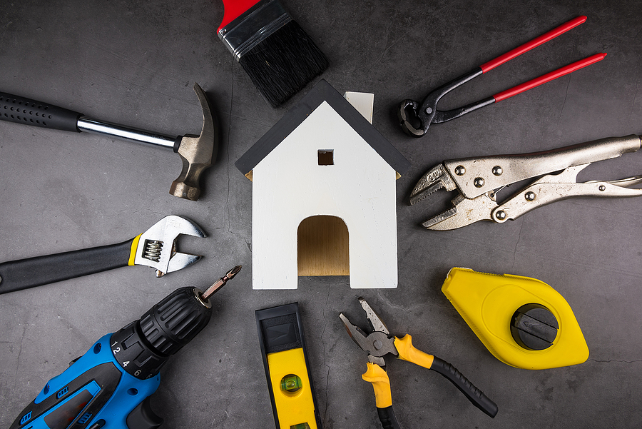 Wooden Model White Houses And Home Repair Hand Tools On A Cement Home Repair Hand Tools on a cement gray background. Concept home repair, Home improvement, Renovate home.Construction Tools Concept