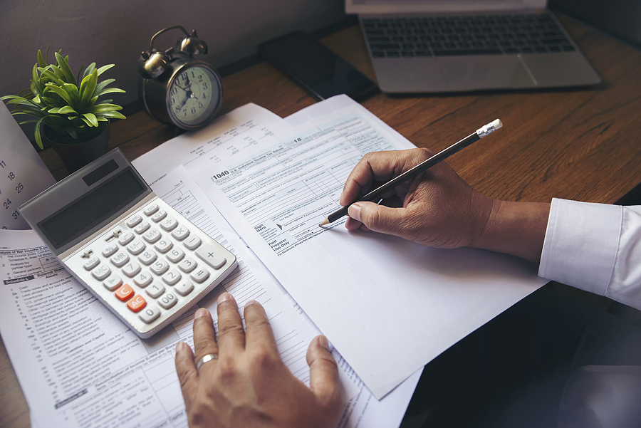Top 3 Tax Forms From Irs You Should Know About Budget planning concept,Accountant is calculating company's annual tax.Calendar 2020 and personal income tax forms for those who have income under US law placed on office desk.This is the season to pay taxes.