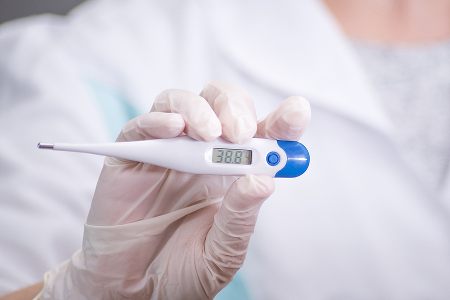 Why is temperature scanning important? Closeup Shot Of A Woman Looking At Thermometer. Female Hands Hol