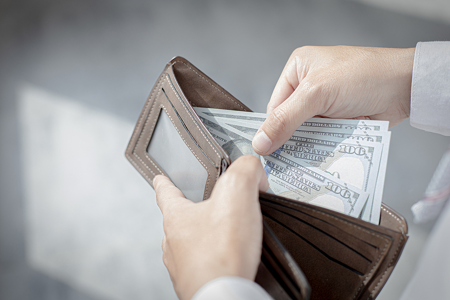 Young man took out the 100 dollar bill from the brown purse, Spending money with cash, Campaign to use cash concept.