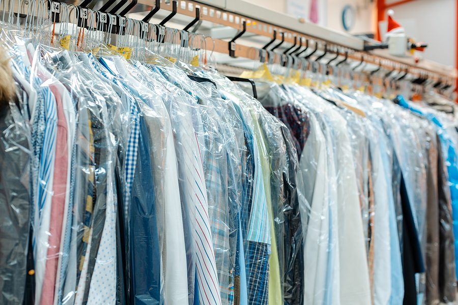 What Should You Expect from Your Pick-Up Laundry Service? Carousel of clothing waiting for pick-up by their owners in dry