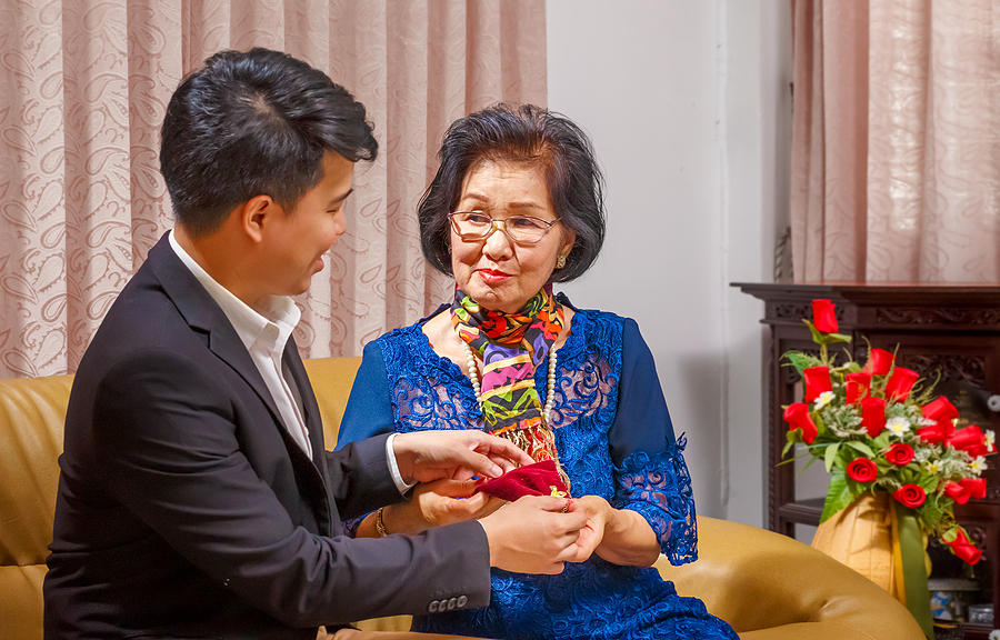 Adult Son Gives A Present To Mother On The Mothers Day
