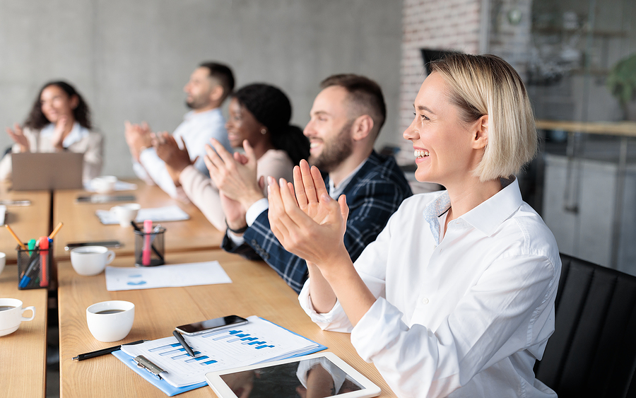 Joyful Coworkers Applauding Celebrating Business Success Sitting At Desk During Corporate Meeting In Office. Teamwork, Successful Team, Business Achievement Celebration. Selective Focus