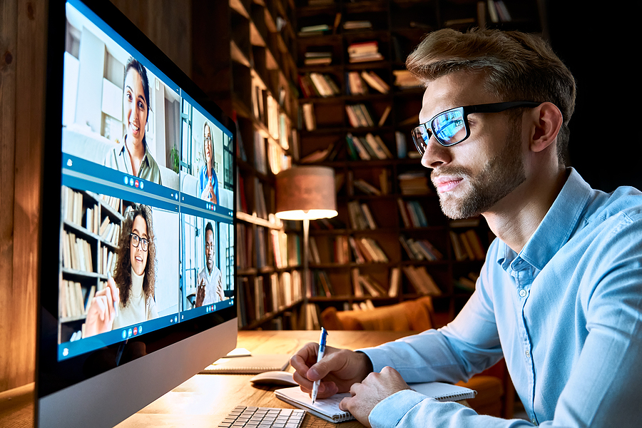How to Build a Unified Culture in a Hybrid Workplace Business man having virtual team meeting on video conference call using computer. Social distance employee working from home office talking to diverse colleagues in remote videoconference online chat. Windows 11
