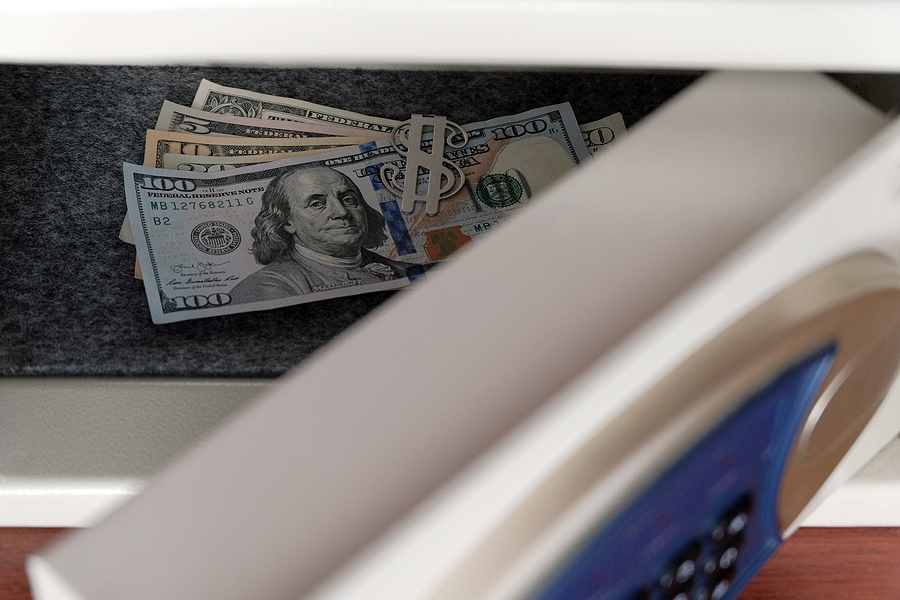 Smart Safe Technology, US dollar bills in a safe deposit box. The concept of saving money in a hotel or bank, storing banknotes in a safe with a combination lock. Selective focus. Shallow depth of field.