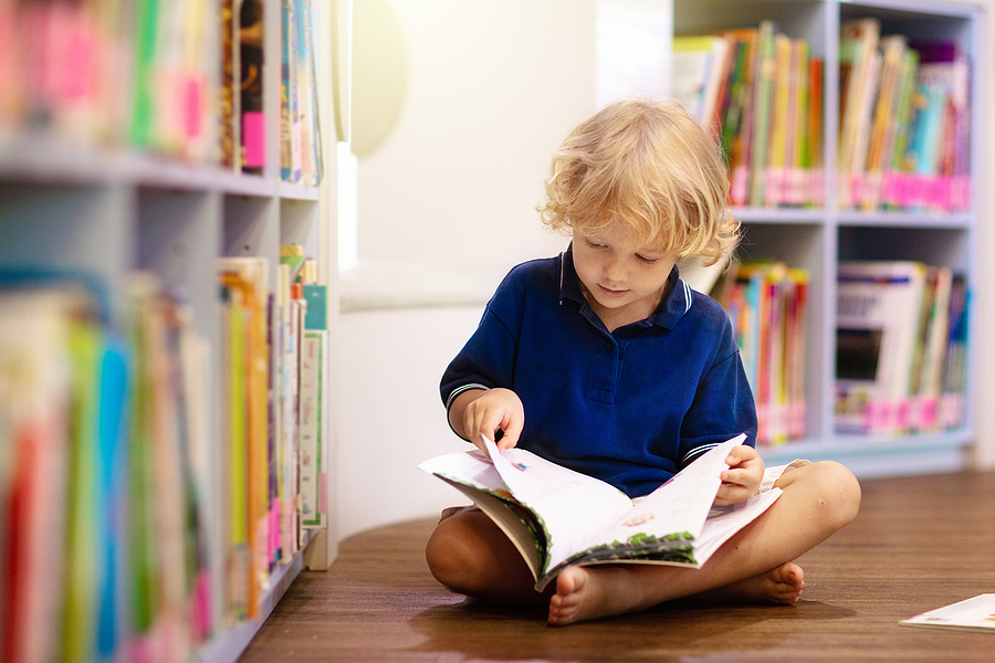 Benefits of Outdoor Activities for Children Development Child in school library. Kids read books. Little boy reading and studying. Children at book store. Smart intelligent preschool kid choosing books to borrow.