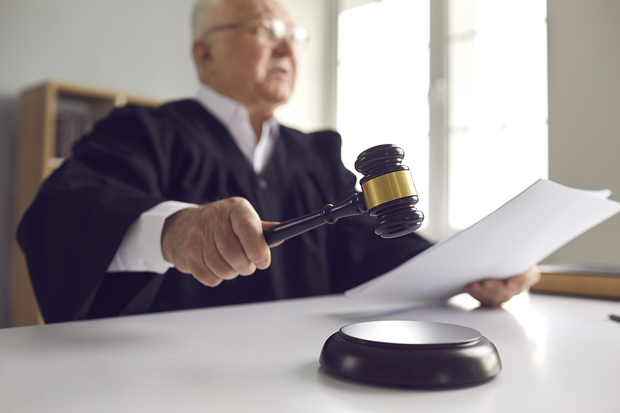 Judge Holding Gavel, Hitting Sound Block And Pronouncing Sentenc