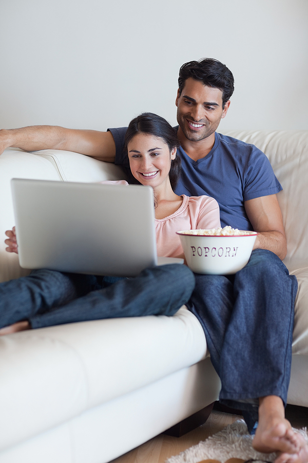 Portrait of a couple watching a movie while eating popcorn with
