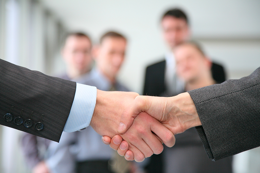 A Linkedin Marketing Strategy: What Are Its Possible Benefits? Shaking hands and business team in business a hall ** Note: Shallow depth of field