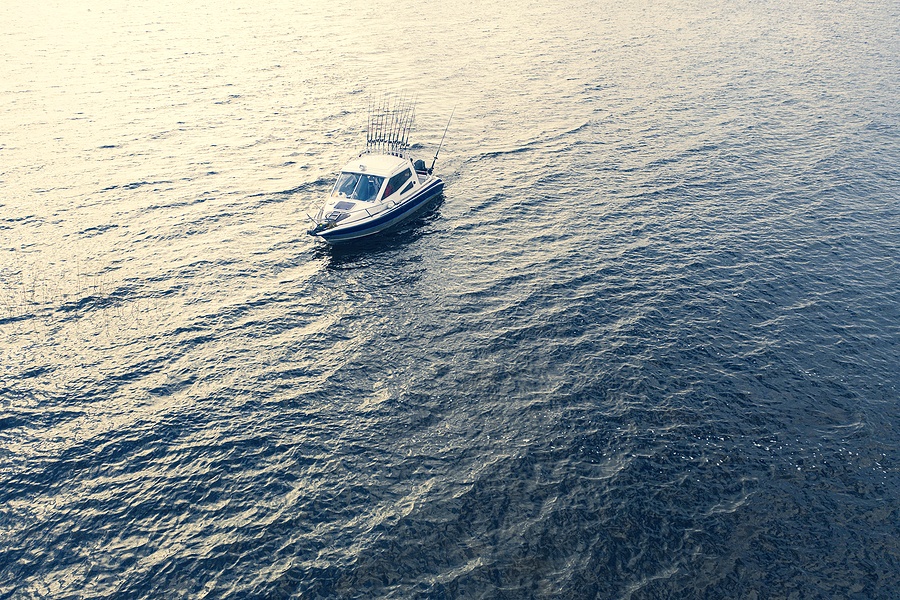 boating Aerial view fisherman on boat at the ocean. Top view beautiful seascape with the fishing boat. Aerial view fishing motor boat with angler. Ocean sea water wave reflections. Motor boat in the ocean.