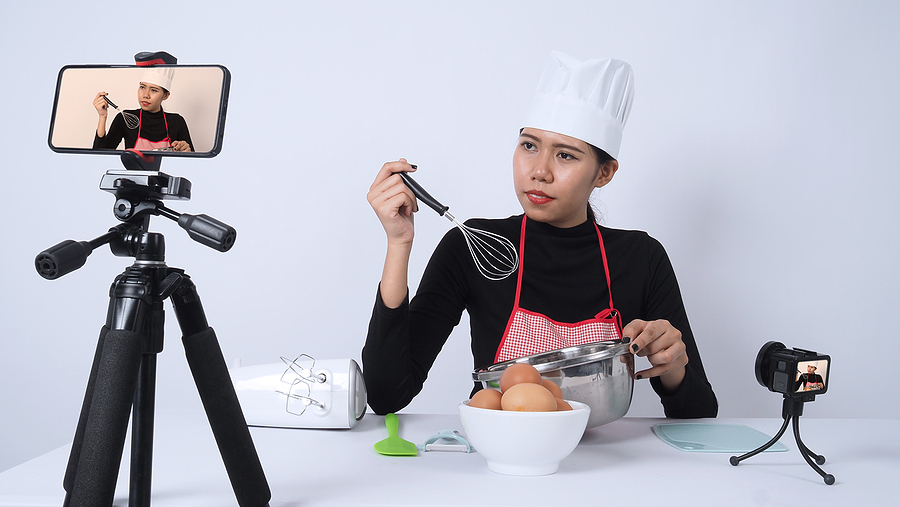 youtube Food blogger. Asian woman chef streaming live. she communicating with subscribers through phone camera online. vlogger and online influencer recording video content on healthy food. Online food instructor.