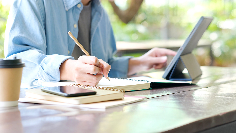 Online studying class, Student man hand writing on notebook while using digital tablet for e learning, Adult male university, college student study online course at home, education, Work from home