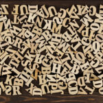 What is C-type printing? Background Is Made Of Wooden Jumbled Letters. English Alphabet.