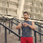 Great progress. Staying fit and healthy. checking his watch while jogging in the morning. Running man with smart watch. Handsome fitness man using smart watch. muscular sportsman looking at device