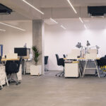 Interior of modern industrial office with desks and computers. E