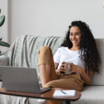 Download Pluto TV videos for Offline Watching Relaxed Pretty Young Woman Watching Movie On Laptop, Drinking Co