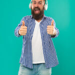 What Tech Gifts Are an Awesome Idea For Your Music-Loving Friend? Excellent sound. Music library concept. Tech gadgets all music lovers should have. Music always with me. Man listening song in headphones. Best gifts for music lovers. Bearded hipster wear headphones.