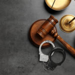 Reasons to Hire a Private Criminal Defense Attorney for Your Case Judge's gavel, handcuffs and scales on grey background, flat lay with space for text. Criminal law concept