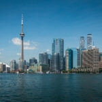 How to Maximize Your Toronto Property with Smart Rentals Toronto skyline with scyscrapers and Lake Ontario on beautiful sunny day as seen from Toronto islands. Blue sky, few clouds, early afternoon. Reflections of skyline in water. No people, copyspace.