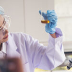 Woman Scientist In Lab Look At Science Microscope Medical Test A