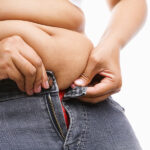 Woman Trying Hand To Zipper Her Jeans