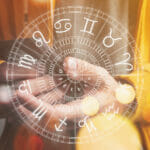 Astrology smartphone app concept, man using mobile smart phone, closeup of hands with astrological chart, selective focus