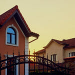 Sunset In A Cottage Village. The Sun Goes Down Behind The Houses
