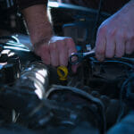 How to Diagnose Wear in a Wrist Pin Engine and What to Do Next Auto mechanic working on car engine in mechanics garage. Repair service. authentic close-up shot