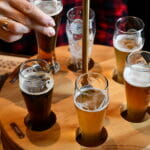 Female Hand Takes Glass Of Craft Beer In Pub To Make Toast Cheer