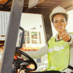 Portrait Female Worker Driving A Forklift Showing His Thumb Up :