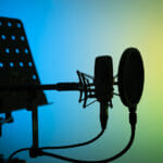 Voiceover artist actor recording voice overs in professional audio studio with large diaphragm cardioid microphone.